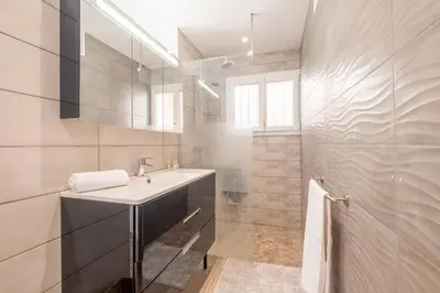 a bathroom with a sink and a mirror at 2-Bedroom Apartment with Garden in Cannes