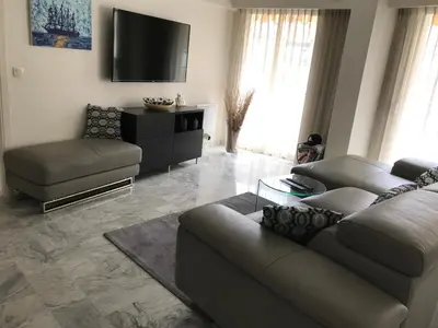 a living room with a couch and a tv at ÉVÈNEMENTS CANNES in Cannes