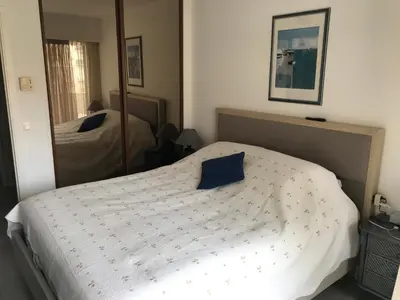 a bedroom with a bed with a blue pillow on it at ÉVÈNEMENTS CANNES in Cannes