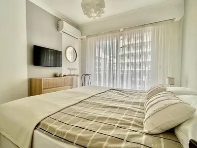a bedroom with a large bed and a window at Palais Lumière in Cannes