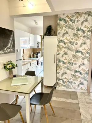 a kitchen with a table and chairs and a refrigerator at Palais Lumière in Cannes