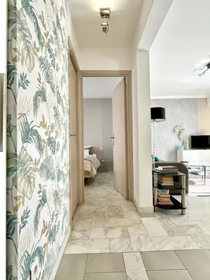 a hallway with a wall with a mural of leaves at Palais Lumière in Cannes