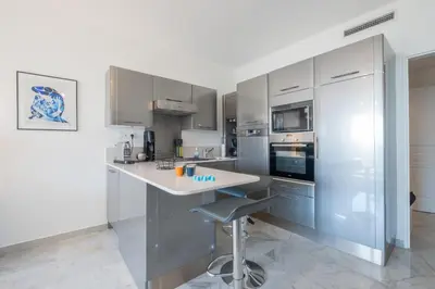 a kitchen with stainless steel appliances and a white counter at RARE! Exquisite 2-bd Apartment Facing the Sea in Cannes