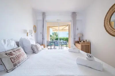 a white room with a large white bed and a mirror at RARE! Exquisite 2-bd Apartment Facing the Sea in Cannes