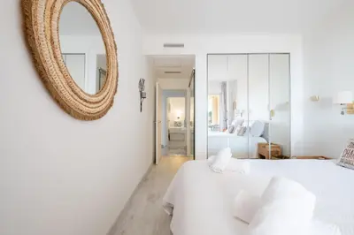 a white bedroom with a mirror and a bed at RARE! Exquisite 2-bd Apartment Facing the Sea in Cannes