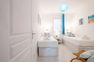 a white room with two beds and a door at RARE! Exquisite 2-bd Apartment Facing the Sea in Cannes