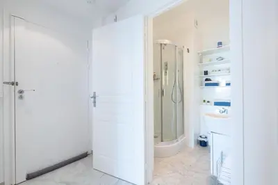 a white bathroom with a shower and a sink at RARE! Exquisite 2-bd Apartment Facing the Sea in Cannes