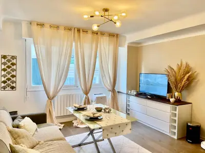 a living room with a table and a tv at Studio Ipanema in Cannes