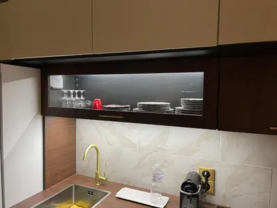 a kitchen with a sink and a shelf with plates at Studio Ipanema in Cannes