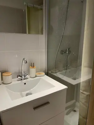 a white bathroom with a sink and a shower at Studio Ipanema in Cannes