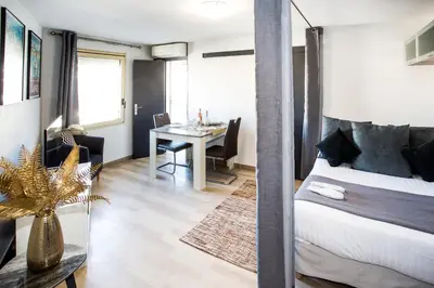 a bedroom with a bed and a dining room at Cannes Studio Centre GAMBETTA in Cannes