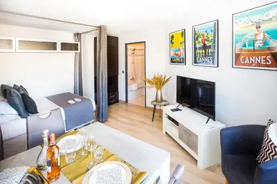 a living room with a couch and a tv at Cannes Studio Centre GAMBETTA in Cannes