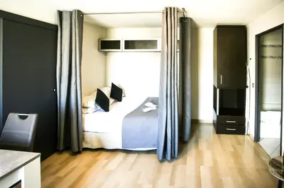 a bedroom with a bed and a large window at Cannes Studio Centre GAMBETTA in Cannes