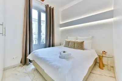 a bedroom with a white bed with a teddy bear on it at Alba apartment antibes street, by Welcome to Cannes in Cannes