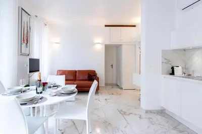 a white living room with a white table and chairs at Alba apartment antibes street, by Welcome to Cannes in Cannes