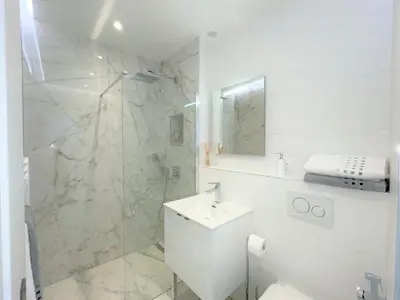 a white bathroom with a shower and a sink at Alba apartment antibes street, by Welcome to Cannes in Cannes