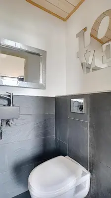a bathroom with a white toilet and a sink at Superbe appartement vue dégagée sur des jardins in Cannes