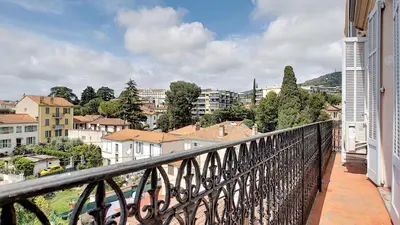 a balcony with a view of a city at Superbe appartement vue dégagée sur des jardins in Cannes