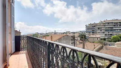 a balcony with a view of a city at Superbe appartement vue dégagée sur des jardins in Cannes