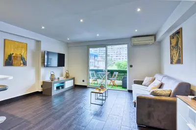 a living room with a couch and a large window at LE VENITIA studio raffiné avec balcon mignon, pour votre séjour à deux in Cannes