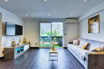 a living room with a couch and a tv at LE VENITIA studio raffiné avec balcon mignon, pour votre séjour à deux in Cannes