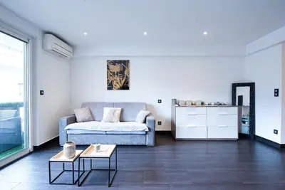 a living room with a couch and a table at LE VENITIA studio raffiné avec balcon mignon, pour votre séjour à deux in Cannes