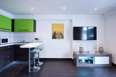 a kitchen with green cabinets and a counter top at LE VENITIA studio raffiné avec balcon mignon, pour votre séjour à deux in Cannes
