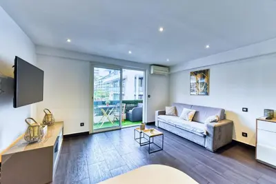 a living room with a couch and a table at LE VENITIA studio raffiné avec balcon mignon, pour votre séjour à deux in Cannes