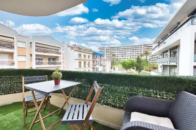 a balcony with a table and chairs and buildings at LE VENITIA studio raffiné avec balcon mignon, pour votre séjour à deux in Cannes