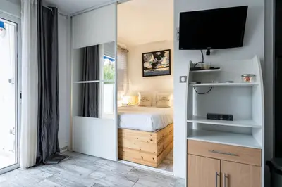 a kitchen with white cabinets and a sink at LE ROYAL Studio adorable avec terrasse, parfait pour les couples et à deux pas de la Croisette in Cannes