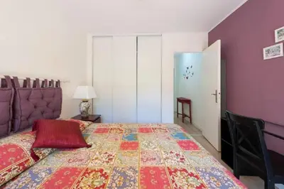 a bedroom with a bed with a colorful quilt on it at LE CARDIFF avec grand balcon, piscine et parking, un fabuleux appartement familial en basse Californie in Cannes