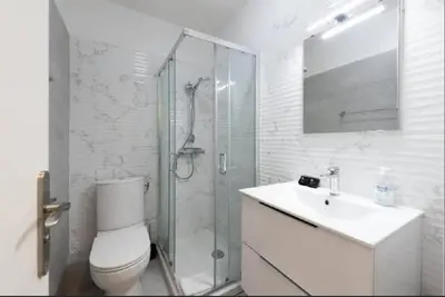 a bathroom with a shower and a toilet and a sink at LE CARDIFF avec grand balcon, piscine et parking, un fabuleux appartement familial en basse Californie in Cannes