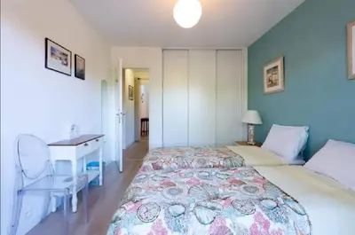 a bedroom with a large bed with a desk and a bed sidx sidx at LE CARDIFF avec grand balcon, piscine et parking, un fabuleux appartement familial en basse Californie in Cannes