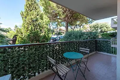 a patio with a table and chairs on a balcony at LE CARDIFF avec grand balcon, piscine et parking, un fabuleux appartement familial en basse Californie in Cannes