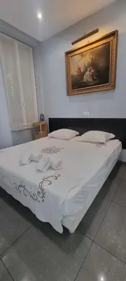 a bed in a bedroom with a picture on the wall at Cannes Hoche Apartment in Cannes