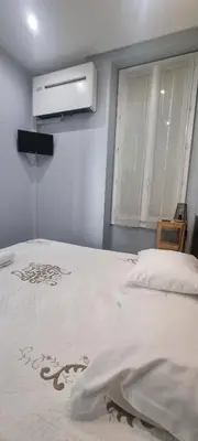 a white bed in a room with a window at Cannes Hoche Apartment in Cannes