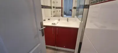 a bathroom with a sink and a red cabinet at Cannes Hoche Apartment in Cannes