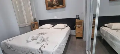 a bedroom with a bed with white sheets and a mirror at Cannes Hoche Apartment in Cannes