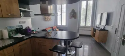 a kitchen with a counter and a table in it at Cannes Hoche Apartment in Cannes