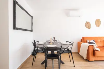 a dining room with a table and chairs and a couch at Comfy apartment with residential swimming pool in Cannes