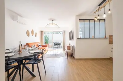 a dining room and living room with a table and chairs at Comfy apartment with residential swimming pool in Cannes