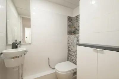 a white bathroom with a toilet and a sink at Comfy apartment with residential swimming pool in Cannes