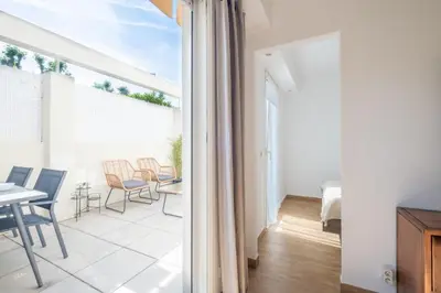 a room with a balcony with a table and chairs at Comfy apartment with residential swimming pool in Cannes