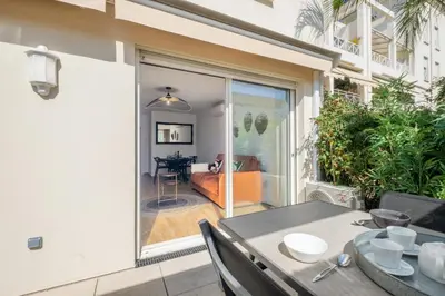 a dining room with a table and a sliding glass door at Comfy apartment with residential swimming pool in Cannes