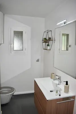 a bathroom with a sink and a toilet and a mirror at Magnifique Appartement 2 pièces au calme in Cannes
