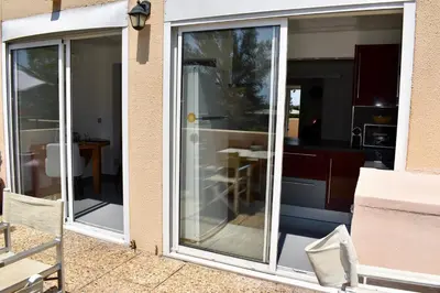 a sliding glass door with a kitchen in the background at Magnifique Appartement 2 pièces au calme in Cannes