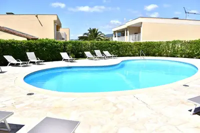 a swimming pool with chairs and a house at Magnifique Appartement 2 pièces au calme in Cannes