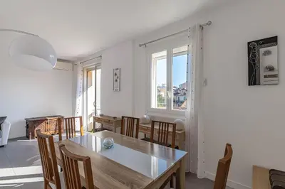 a dining room with a table and chairs and a window at Appt lumineux et spacieux au cœur de Cannes in Cannes