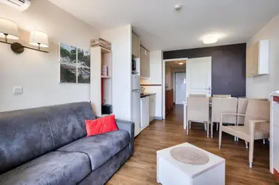a living room with a couch and a kitchen at Résidence Cannes Villa Francia - maeva Home - Appartement 3 pièces 7 personnes - Sélection MAE-0244 in Cannes