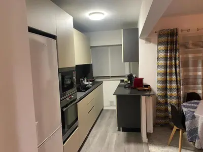 a kitchen with white cabinets and a black counter top at bien-être in Cannes